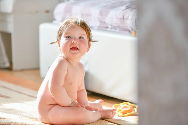 Child is sitting in the bedroom. Baby boy crawling on bed. Little child playing in white sunny bedroom. Infant kid learning to crawl. Nursery for children. Textile, clothing and bedding for kids. Fami — Stockfoto
