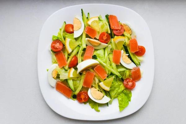 Insalata di verdure su un piatto bianco. Insalata fresca con uova, pomodori, spinaci e avocado su sfondo bianco vista dall'alto. Cibo sano . — Foto Stock