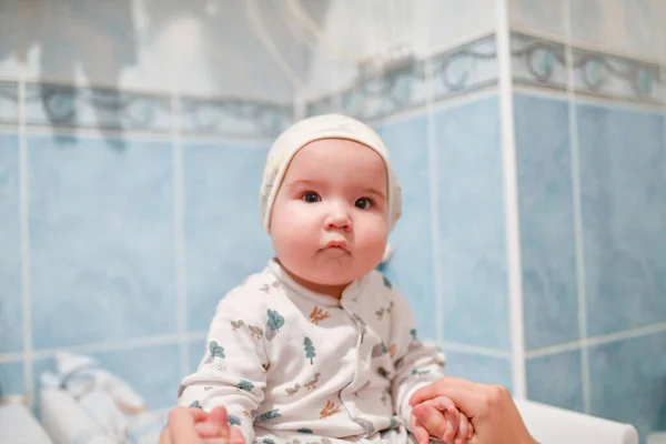 Дитина після купання. Маленька 8-місячна дитина після купання на міняючому килимку . — стокове фото