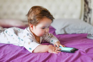 Çocuk cep telefonuyla öğreniyor. Küçük yeni doğmuş bebek cep telefonuna uzanıyor 