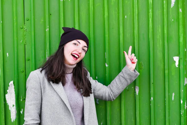 Девушка на зеленом фоне. носить шляпу и пальто. место для записи. одетый в холодную пагоду. одежда и стиль. естественные эмоции. Портрет молодой женщины на зеленом фоне — стоковое фото