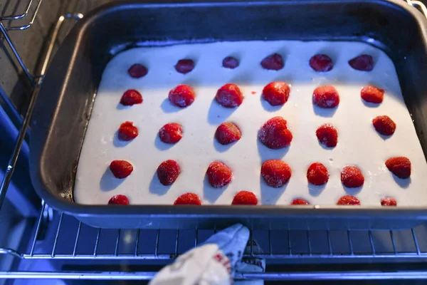 base for strawberry pie in the oven. Healthy fresh strawberry and banana tart or pie with cream on a freshly baked golden pie crust served on a baking tray and oven paper