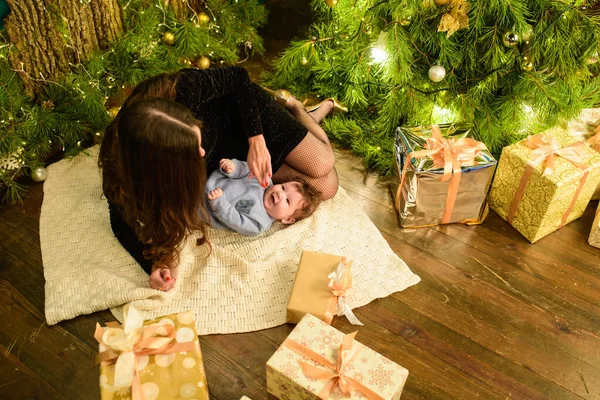 Conceito de Natal e mãe. Conceito de Natal e pessoas - mãe e bebê com presentes. Num fundo natalício. Natal quente . — Fotografia de Stock