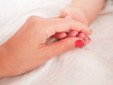 Annem yeni doğmuş bir bebeğin elini tutuyor. Yakın plan. Yazacak bir yer. Metin yerleştiriliyor. Odaklanamıyorum. Bebeğin eli anneye uzanıyor..