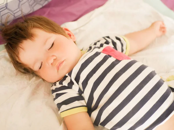 睡在父母床上的孩子。 0-1岁的婴儿。 一个新生儿在父母床上的肖像。 宝宝白天的睡眠。 儿童的无忧无虑的生活。 睡个好觉. — 图库照片