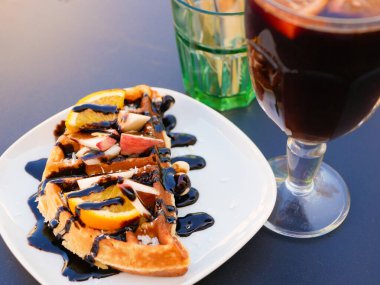 Limonlu Viyana waffle 'ı. Çikolataya bulanmış. Yakın plan. Yukarıdan bak. İçkiler arka planda. Lezzetli kahvaltı.