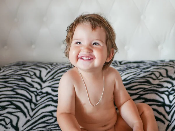 El bebé desnudo se ríe. ríete entre todos tus dientes. Feliz bebé riendo. Dientes blancos de un bebé recién nacido. Risa natural. Bebé despreocupado . — Foto de Stock