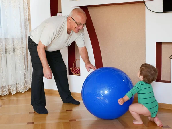 Dziadek gra w piłkę z wnukiem. Relacja między dziadkiem a wnukiem. Dziadek, trening, koncepcja uczenia się. Koncepcja związków i ludzi. Nowe pokolenie. Niebieska piłka — Zdjęcie stockowe