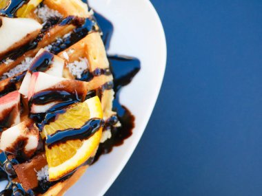 Limonlu Viyana waffle 'ı. Çikolataya bulanmış. Yakın plan. Yukarıdan bak. İçkiler arka planda. Lezzetli kahvaltı.