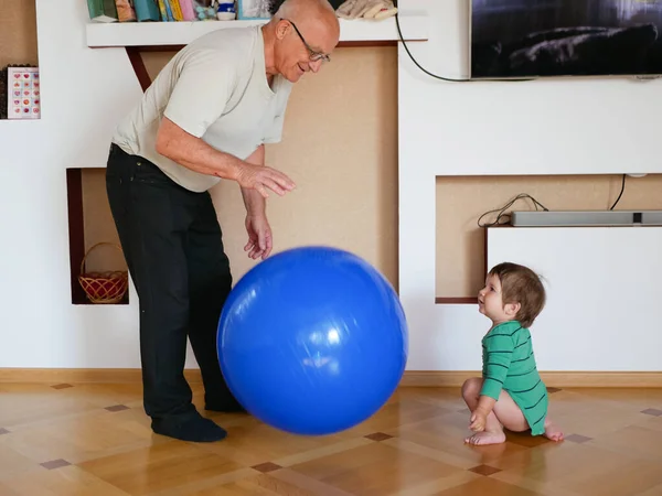 Дедушка играет с внуком дома. Дедушка и внук играют с игрушками дома. Семейные отношения между дедушкой и внуком. Дедушка, обучение, концепция обучения. Концепция — стоковое фото