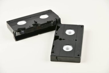 Beyaz arkaplandaki Retro nesneler. Düğmeye basılı telefon ve video kaset. Geçmişin analog medya teknolojisi. Boşluğu kopyala