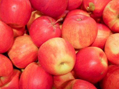 Dükkandaki elmalar. Alıcılar süpermarket standından elma seçer ve satın alırlar. Yakın plan. Mağazada taze kırmızı büyük elmalar kutular içinde. 