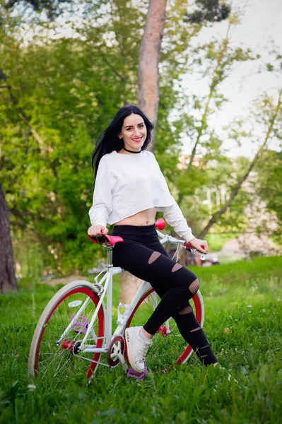 Menina de esportes monta uma bicicleta. emoções e estilo de vida. Jovem mulher bonita andando de bicicleta no parque. Pessoas activas. Na rua. estilo de vida saudável — Fotografia de Stock