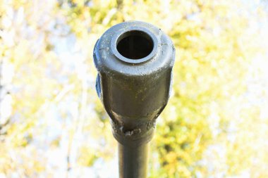 Yakından tankı olan bir fıçı. Paslı bir askeri tank silahının yakından çekimi, tank topu. Sovyet tanksavar tüfeğinin namlusu. Topçu tüfeği yakın çekim. Sığ alan derinliği.