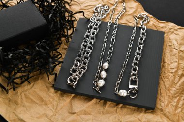 Gümüş kolye. Yakın plan. Tahta bir tezgahta yatıyordu. Yukarıdan bak. Mücevher ve mücevher kavramı. Kadınlar için hediyeler. Alışveriş. El işi.