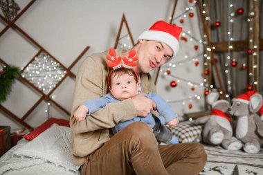Geyik boynuzlu bebek. Mutlu yıllar. Childs takımı. Noel zamanı. Baba kollarını tutar ve sağa sola sallar..