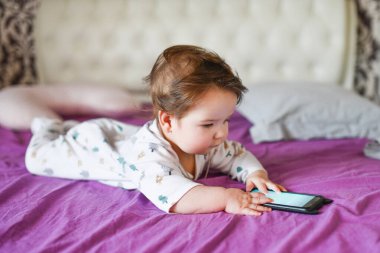 çocuk boş ekranlı bir cep telefonunun ekranına bak: anne ve bebek için mobil uygulamanın düzeni