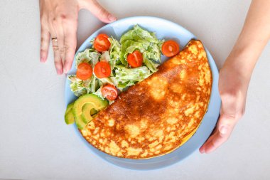 Sebzeli omlet. Mavi tabak. Yukarıdan bak. Kahvaltıda servis edilen sebzeli omlet. Yukarıdan görüntüle