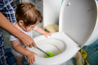 Annem bir çocuğa temizlik yapmayı öğretiyor. Bebeğin arkasını temizliyorum. Tıkanmış tuvalet. Anne ve bebek tuvaleti temizliyor. Ev temizliği.