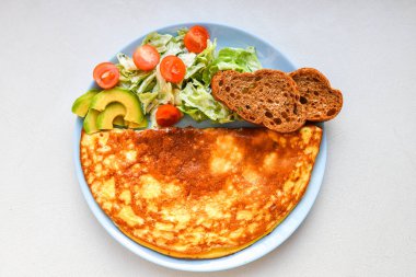 Yumurtalı taze sebzeler. Yuvarlak bir tabakta. Mantarlı omlet.