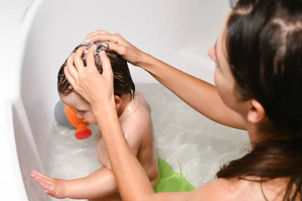 Mom washes the babys head. Joint bathing baby and mom. A symbol of cleanliness and hygiene education. — Stock Photo, Image