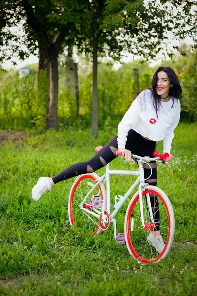 Спортивная девушка ездит на велосипеде. эмоции и образ жизни. Молодая красивая женщина на велосипеде в парке. Активные люди. На улице. здоровый образ жизни — стоковое фото