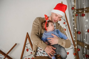 Noel arkaplanındaki bebek ve baba. Mutlu aile babası ve çocuğu Küçük kız oğlu ve noel mucizesi