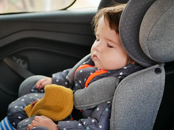 The boy is sleeping in a car seat. Driving safety for the child. 0-1 year old baby sleeping in a car seat — Stock Photo, Image