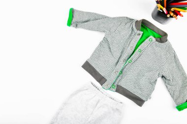 Beyaz arka planda bebek kıyafetleri. Düz yat. Kareli ceket. Yazmak için bir yer. Çocuk modası..