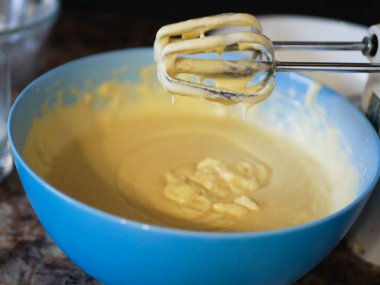 Hamuru bir tabakla karıştırıcı ile karıştır. Karıştırıcıdaki turtanın hamuru. Bulanık bir arkaplanda. Geniş görünüm