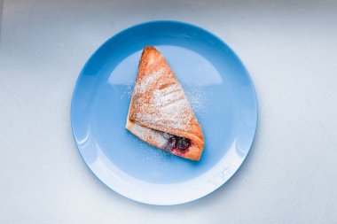 Mavi tabakta Kurasan. Curasan 'la kahvaltı ve beyaz bir masada kahve. Mavi bir tabakta. Meyveli. ev yapımı