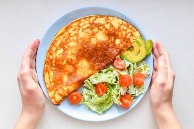Sebzeli omlet. Mavi tabak. Yukarıdan bak. Kahvaltıda servis edilen sebzeli omlet. Yukarıdan görüntüle