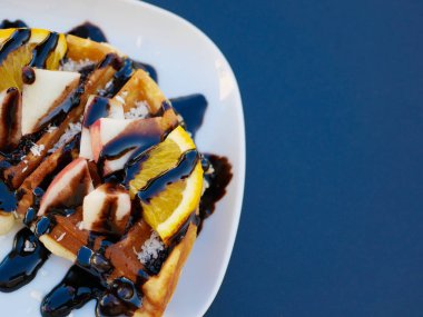 Limonlu Viyana waffle 'ı. Çikolataya bulanmış. Yakın plan. Yukarıdan bak. İçkiler arka planda. Lezzetli kahvaltı.