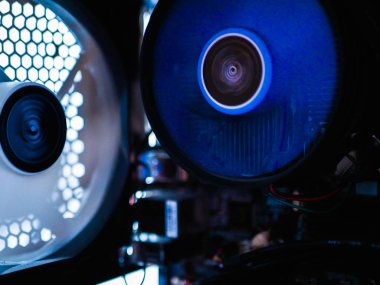 Bilgisayarın sistem ünitesinde soğutucu. Bilgisayar için fan yak. Metal ağ bilgisayar kutusu. Sistem ünitesinin neon ışığı, ışıklar, gece görüşü. Dikkatini ver. hafif bulanık