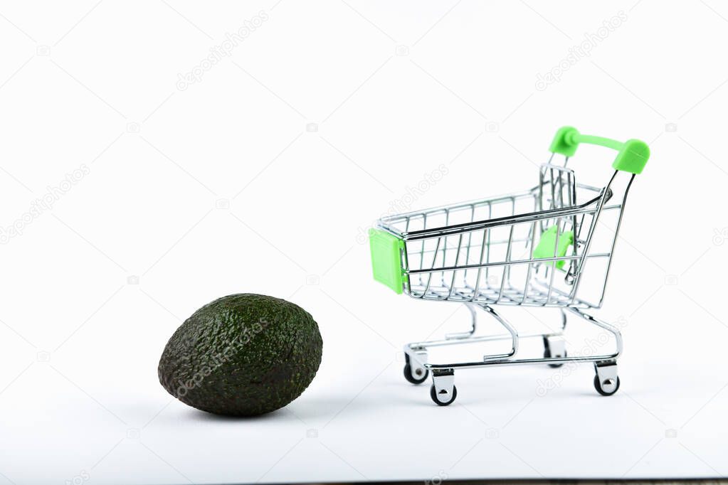 Buying Avocados trading concept. Online store. Cart and avocado over a white background. business concept healthy eating concept