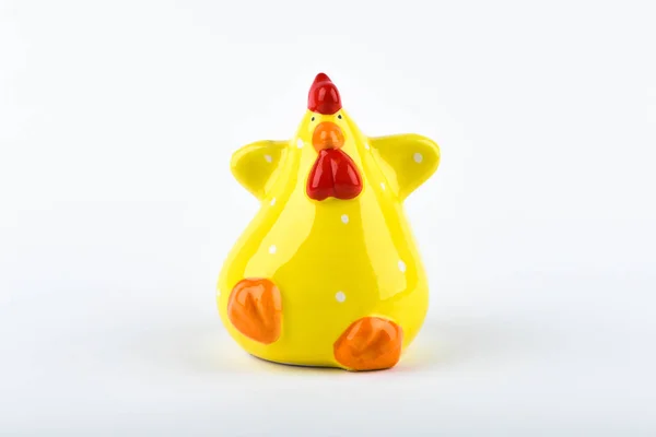 Funny chicken on a white background. Figurine of yellow chicken.