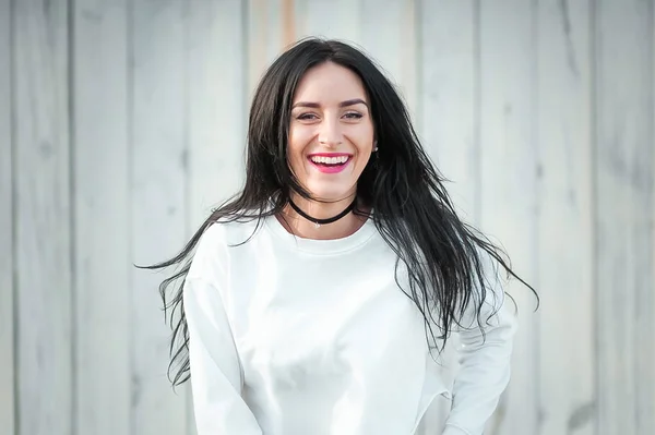 Retrato de uma bela jovem mulher em uma camiseta branca com cabelo preto. alegria e riso degenerado. emoções positivas. Estilo de vida. beleza e juventude. sobre um fundo branco Emoções positivas e alegres — Fotografia de Stock