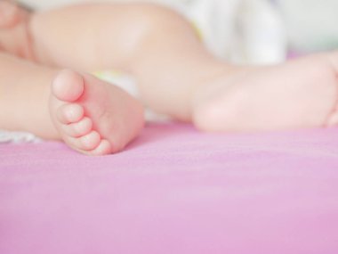 Çocuk ayağı. Örülmüş pastel bir battaniyeye benziyor. Yakın plan. Yazacak bir yer. Metin yerleştiriliyor. odağını kaldır