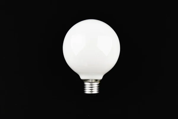 Round light bulb on a black background. place for an inscription. view from above. — Stock Photo, Image