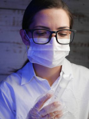 Hemşireye yakın dur. Doktor hemşire, bir cerrahın maskesinin arkasında. Siyah gözlüklü beyaz bir kadının yakın plan portresi.