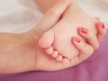 Çocuk ayağı. Örülmüş pastel bir battaniyeye benziyor. Yakın plan. Yazacak bir yer. Metin yerleştiriliyor. odağını kaldır
