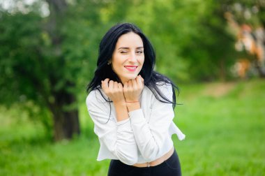 Beyaz tişörtlü, siyah saçlı güzel bir kadının portresi. Neşe ve kahkaha yozlaşmış. pozitif duygular. Yaşam tarzı. güzellik ve gençlik. beyaz bir arka planda pozitif ve neşeli duygular