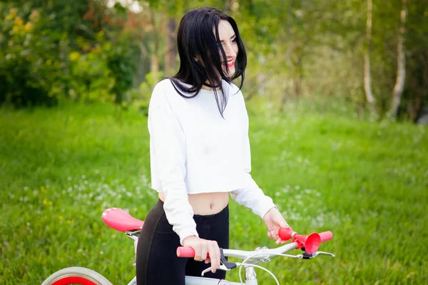 Sportmeisje rijdt op een fiets. emoties en levensstijl. Jonge mooie vrouw op een fiets in het park. Actieve mensen. Op straat. gezonde levensstijl — Stockfoto