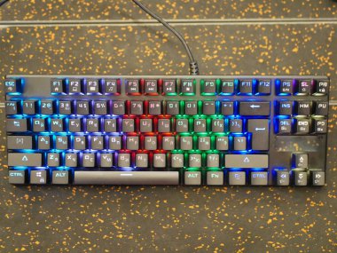 Rgb klavyesi. Renkli bir klavye farklı renklerde parıldıyor. Masada yatıyordu. Yumuşak bokeh