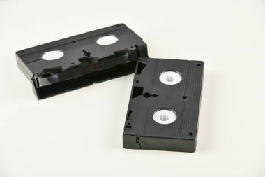 Beyaz arkaplandaki Retro nesneler. Düğmeye basılı telefon ve video kaset. Geçmişin analog medya teknolojisi. Boşluğu kopyala