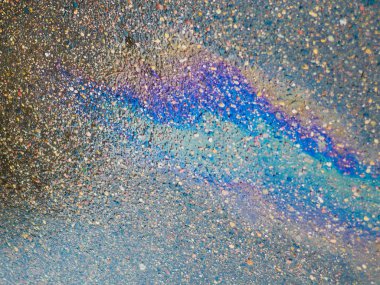 Kaldırımda bir benzin birikintisi. Yakın plan. Islak asfalt yolda sızan benzin. Islak asfalt yolda sızan renkli benzin. 