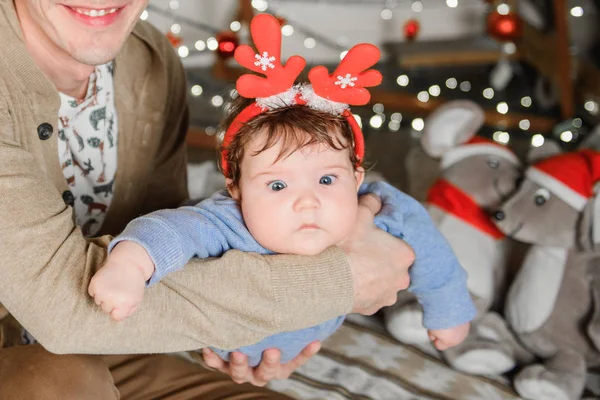 Geyik boynuzlu bebek. Mutlu yıllar. Childs takımı. Noel zamanı. Baba kollarını tutar ve sağa sola sallar.. — Stok fotoğraf