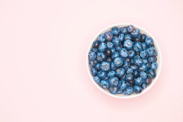 The usefulness of blueberries. Closeup of blueberry berries with hands in a light dish background. Photo of blueberries for designers on the banner. Useful berries for vision. love for berries — Stock Photo, Image