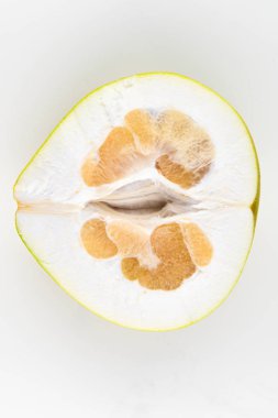 Beyaz arka planda pomelo kes. Olgunlaşmamış. İçi küçük. Yazı için uygun bir yer. Kolay kesim. Yukarıdan bak. yakın plan.