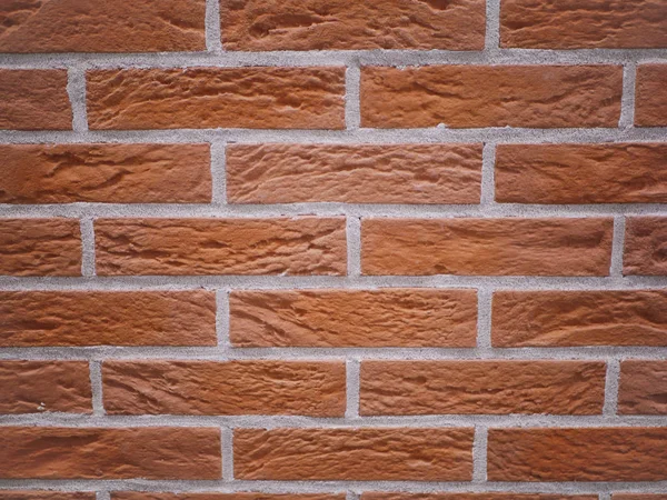 Pomarańczowa ceglana fasada. Rozdarta struktura kamienia. Kamienny mur. abstrakcyjne tło — Zdjęcie stockowe